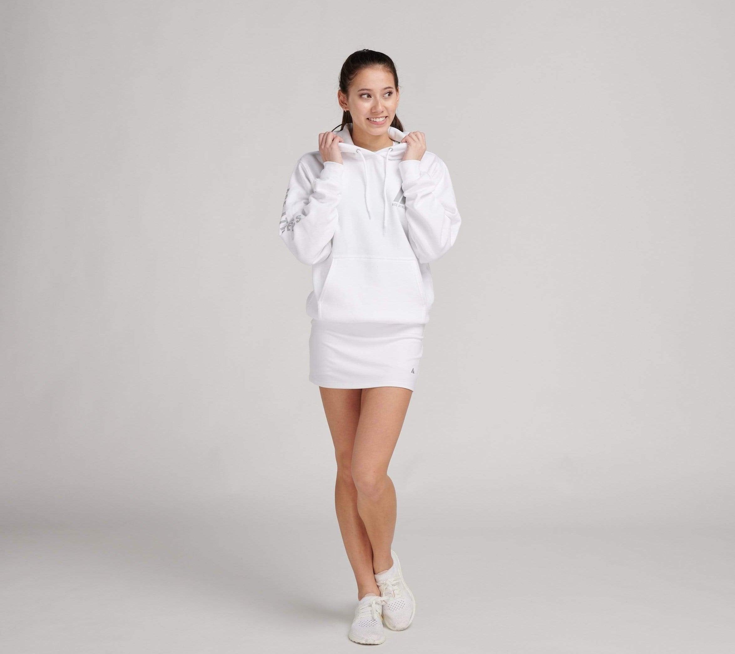 woman wearing white sweatshirt and white tennis skirt